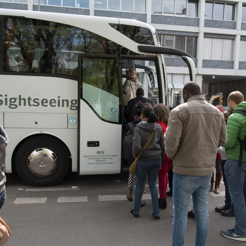 Menschen steigen in einen Reisebus. Foto: Jonas Walzberg