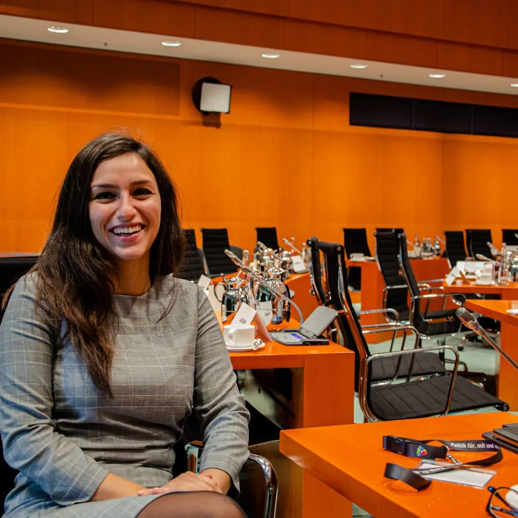 Teilnehmerin sitzt im Konferenzraum des Bundeskanzleramtes