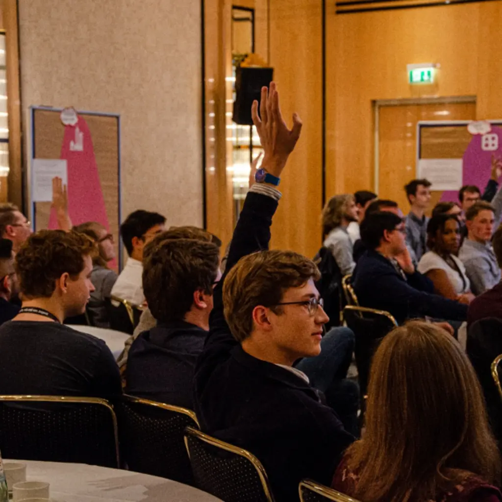 Junge Menschen sitzen in einem Raum und diskutieren.