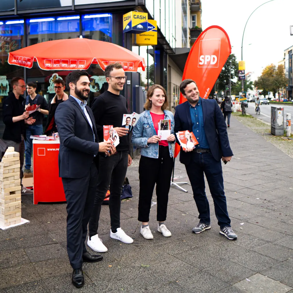 Annika Klose steht mit ihrem Wahlkampfteam vor dem Stand der SPD und posiert für eine Kamera außerhalb des Bildes.