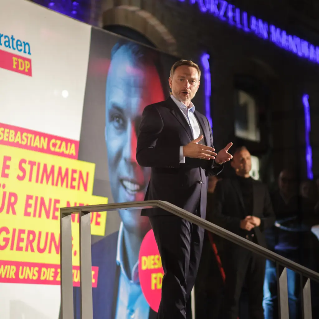 Christian Lindner steht auf der Bühne vor einem großen Wahlplakat und hält eine Rede.