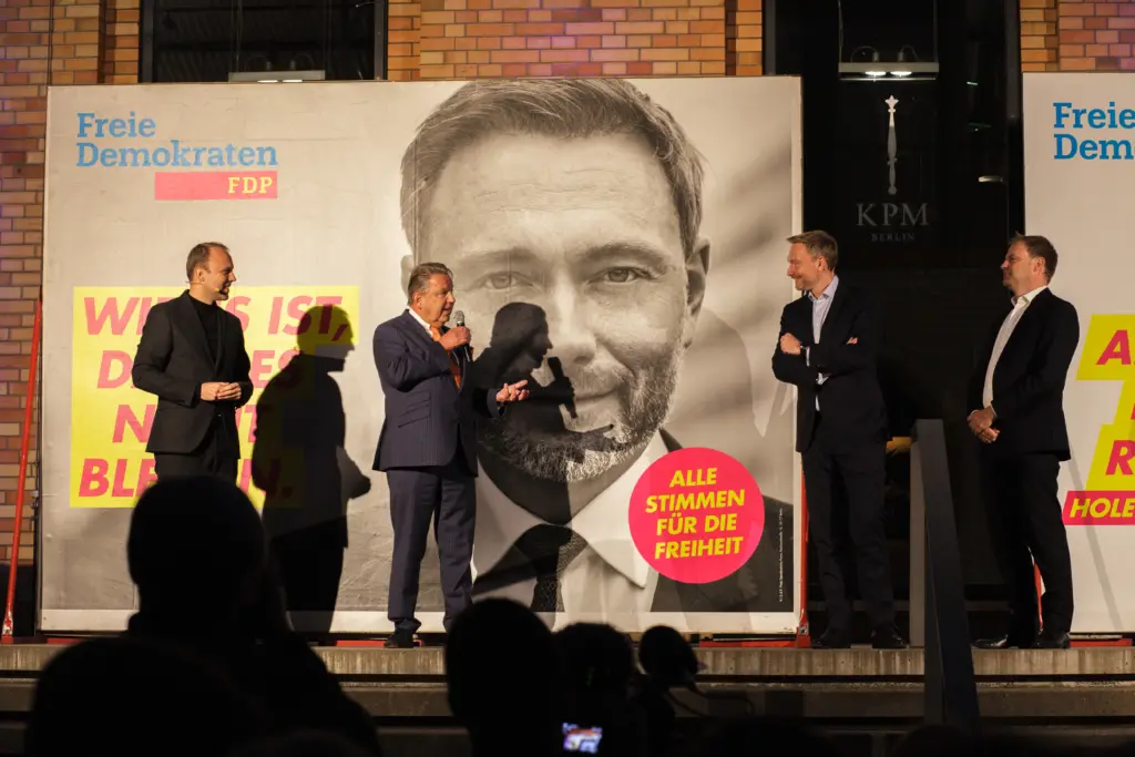 Sebastian Czaja, Jörg Woltmann, Christian Lindner und Christoph Meyer stehen auf der Bühne vor dem Wahlplakat von Christian Lindner und sprechen miteinander.